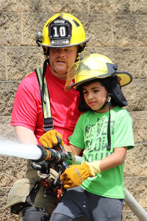 student and instructor with fire hose